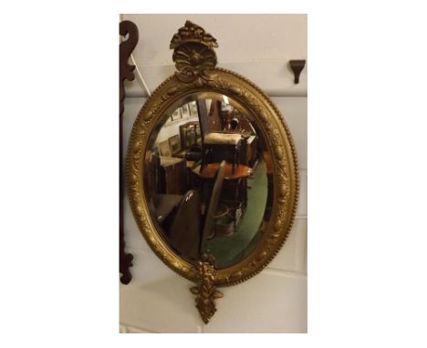 Victorian oval wall mirror with painted gold finish, foliage relief and shelf mounted detail, 16" x 27" 