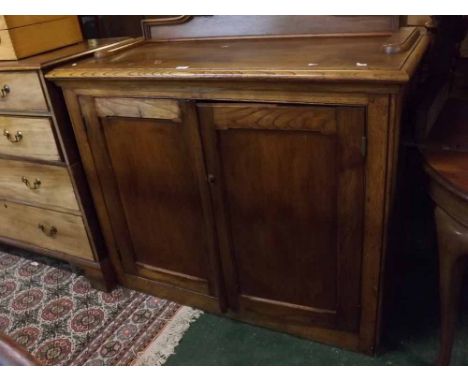 Early 20th century oak buffet, the moulded top with shaped back board over two panelled doors with fitted shelf   