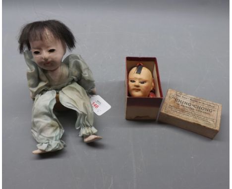 Small Japanese porcelain doll seated on a basket together with a boxed Ching Chong animated Chinaman finger puppet (2) 