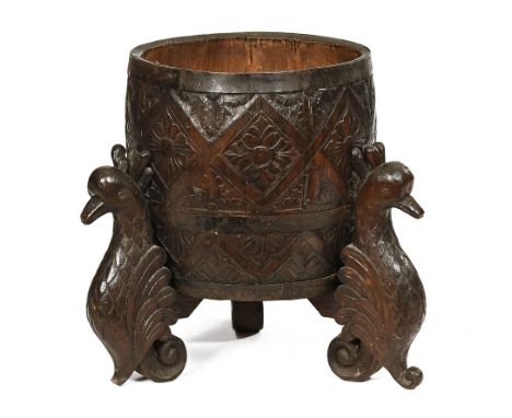 A carved oak barrel form jardiniere planter or log receiver, raised on bird supports.  Height 53.5 cm, top diameter 40 cm.
