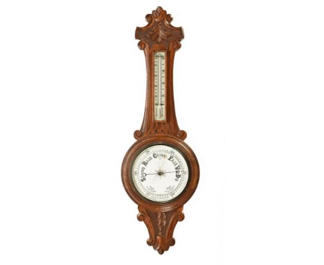 An oak aneroid barometer with mercury thermometer, with carved case.  Height 89 cm, diameter 28 cm.