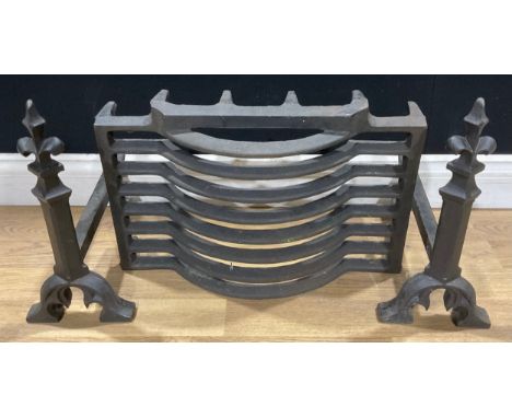 A Gothic Revival cast iron architectural fire grate and dogs, the finials decorated with fleur de lys, 38cm high (3)