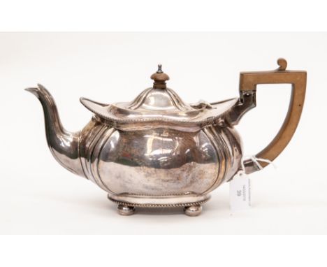 A Continental probably silver teapot, shaped oval with wavy rim on four ball feet, C-scroll fruitwood handle and pagoda finia