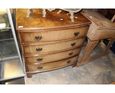 A George V walnut bow fronted chest of drawers, raised on bracket feet