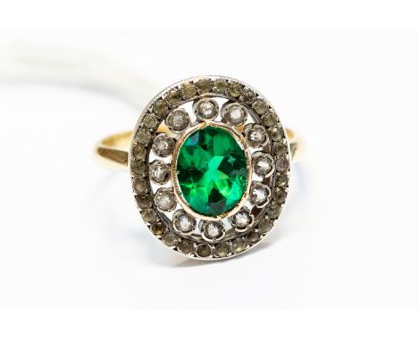 A green stone set dress ring, continental gold French, 18ct gold mark to exterior shank, the oval green stone set to the cent