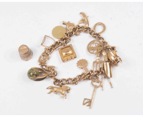 A 9 ct yellow gold charm bracelet with numerous charms (champagne/wine bucket charm detached) total weight approx 30 grams