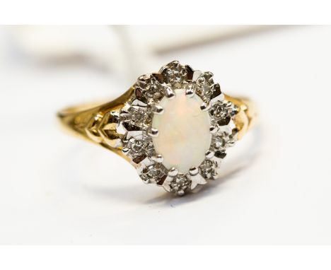 A opal and diamond cluster ring, the oval claw set opal with a border of diamonds set in 9ct gold, size K, total gross weight