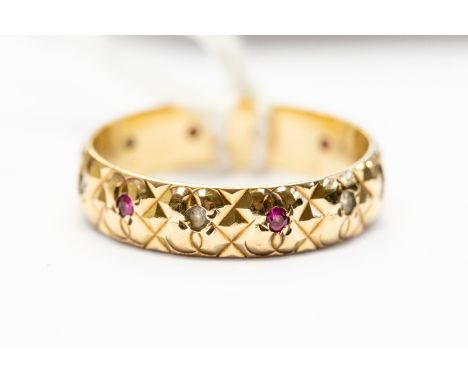 A stone set 9ct gold band, machine cut texture set with alternate ruby and white stones, size O, total gross weight approx 2.