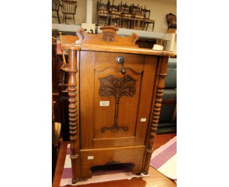A light oak bedside purdonium with a carved front.