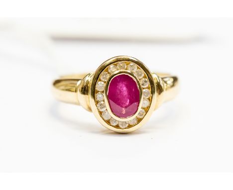 A ruby and diamond set ring, the oval cut ruby weight approx 0.60ct, with a channel set diamond surround, 9ct gold, size  K1/