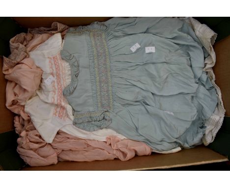 A collection of childrens dresses to include a white smock dress 1920, a blue smock dress 1920, two cotton babies dresses ear