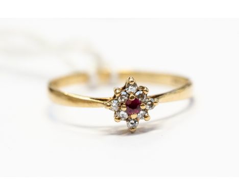 A ruby and diamond set cluster ring, round cut ruby to the centre with a claw set diamond surround, head approx 5mm, set in 9