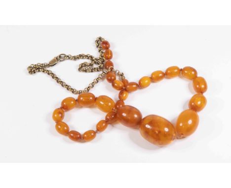 An amber and gold plated necklace, comprising oval graduated amber to the front with gold plated chain detail to the reverse,