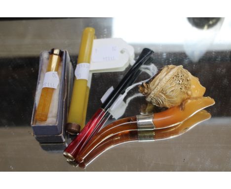 A Victorian Meerschaum pipe depicting a female with amber tip together with three cigarette holders (4)