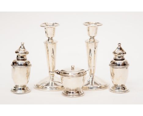 A small quantity of silver to include a pair of candlesticks approx 13cms high, a matching salt and pepper and a hinged musta