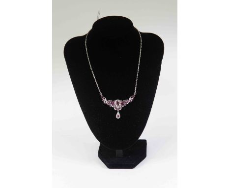 A ruby and diamond necklace, the front set with oval and round cut rubies, with entwined diamond accents with tear shaped dro