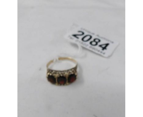 A 9ct gold ring set 3 red stones, size R.