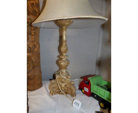 A carved table lamp with shade.