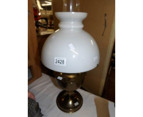 A brass oil lamp complete with shade and chimney.