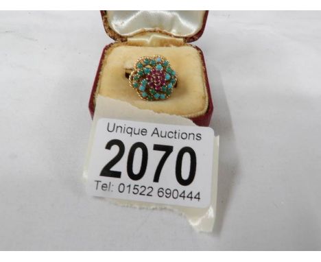 An 18ct yellow gold textured ring fashioned as a ring set with ruby and turquoise stones, 7.3 grams, circa 1970's, size K.