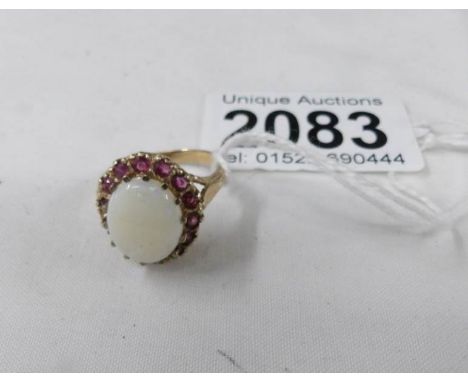 A 9ct gold ring set large opal with red stone surround, size P.