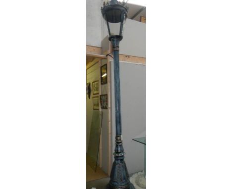 A tall street lamp with lantern top.