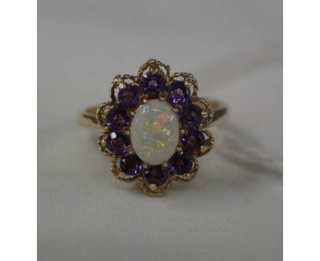 A floral head 9ct gold dress ring with petals of purple stones and central opal. size O.