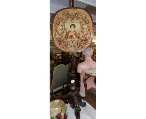 A Victorian mahogany pole screen on carved tripod base and with tapestry panel.