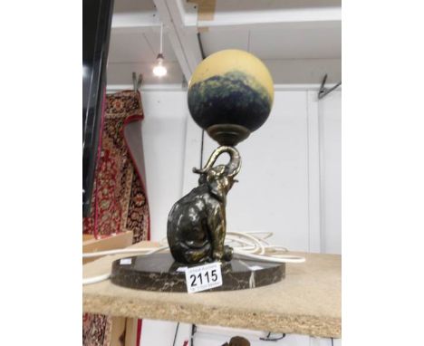 A table lamp of an elephant balancing a ball on trunk.