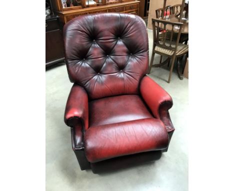A deep red leather manual reclining arm chair