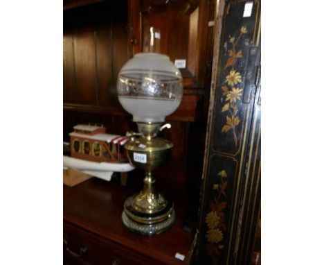 A Victorian brass oil lamp with later shade.
