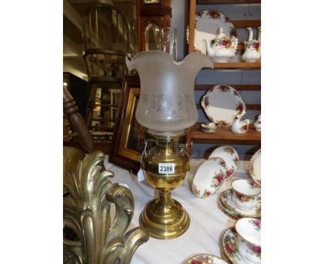 A brass oil lamp complete with shade and chimney.