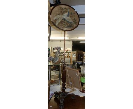 A Victorian mahogany pole screen on tripod base and with tapestry panel.