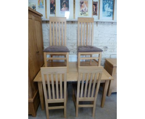 A light oak pull out dining table with one leaf and four chairs with suede seats - in good condition - Table Height 77cm x 14