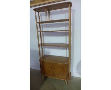 An Ercol light elm room divider with a shelved top above two cupboard doors - some usage marks but reasonably good condition 