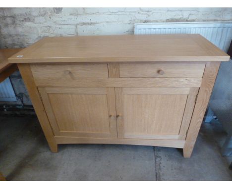 A light oak two drawer two door sideboard matching previous lot - Height 88cm x 121cm x 47cm in good clean condition