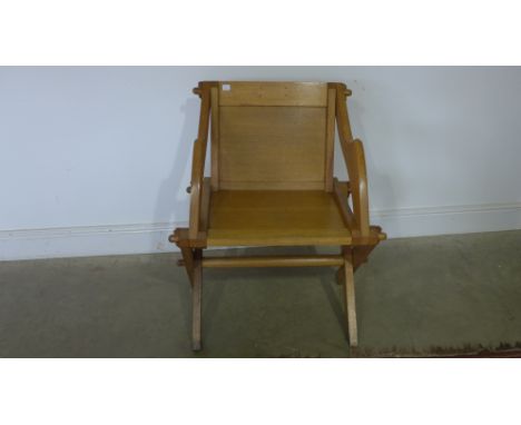 An early 20th century light oak X-framed throne chair 