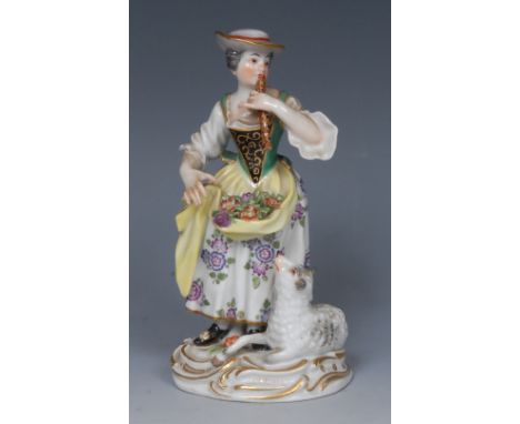 A 20th century  Meissen figure,  of a girl playing a flute, she stands wearing a broad brimmed hat, flowers in her apron, a s