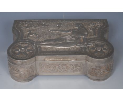 An Indian Art Deco silver box, hinged cover chased with a lady of the court reclining in parkland, lotus to angles, on a text