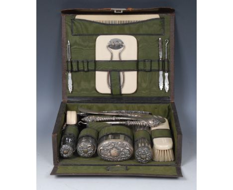 A Victorian  lady's dressing table travelling case, comprising four various faceted clear glass jars, silver covers embossed 