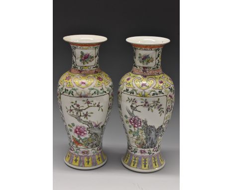 A pair of Chinese famille rose vases, decorated with a peony and blossoming branches, in a shaped panels, the ground with lot
