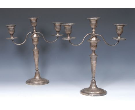 A pair of Edwardian silver three-light table candelabra, in the Adam Revival taste, detachable nozzles, fluted sconces, pilla