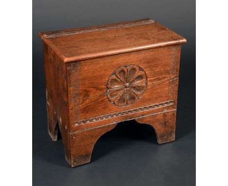 A 19th century elm six plank chest, of small proportions, hinged top, the front carved with a leafy boss, shaped bracket feet