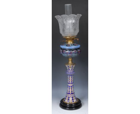A 19th century oil lamp, the cased glass column enamelled with flowers and foliage, opaque glass reservoir painted with passi