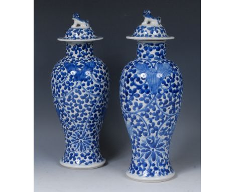 A pair of Chinese baluster vases and covers, decorated in underglaze blue with scrolling lotus and foliage, domed cover, Dog 