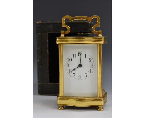 An early 20th century gilt brass shaped serpentine carriage timepiece, 5.5cm rectangular enamel dial inscribed with Arabic nu
