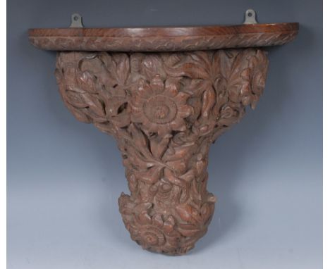 A 19th century Black Forest type wall bracket, trefoil plateau above a wolf a profusion of flowers and scrolling leafy foliag