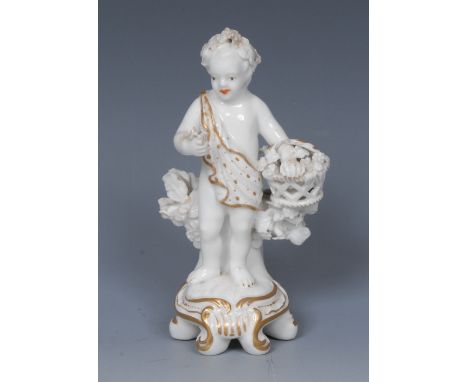 A Chelsea figure, of a scantily clad putto, he stands beside a tree trunk, holding a basket, picked out in gilt, Rococo scrol