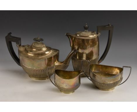 A George V silver four piece half-fluted oval tea service, comprising teapot, water pot, milk jug and sugar basin, angular sc