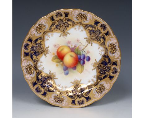 A Royal Worcester shaped circular plate, painted by Albert Shuck, signed, with ripe apples  and blueberries, within fancy gil